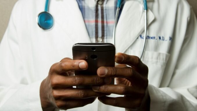 Doctor using an app on a smartphone device as healthcare regulator MHRA is fast-tracking new AI tools that promise to dramatically improve patient care.