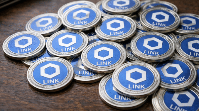 Physical Chainlink (LINK) tokens arranged in a pile on a wooden surface.