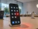 iPhone displaying suspicious wallet-style app icons with one glowing red inside an Apple Store, symbolizing concerns over fake crypto apps on the App Store under new leadership